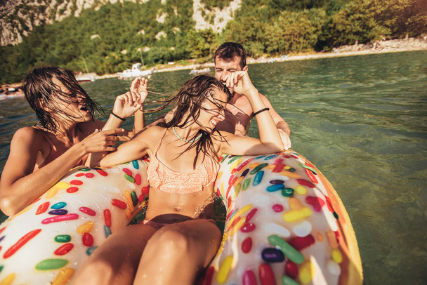 Νέοι μοντέρνοι άνθρωποι που διασκεδάζουν κολυμπώντας στις καλοκαιρινές διακοπές - Φωτογραφία, εικόνα