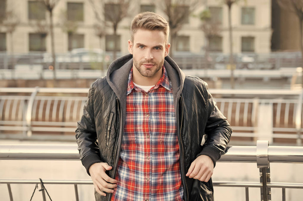 Cool and confident. Facial hair and skin care concept. Handsome face. Handsome man unshaven face and stylish hair. Caucasian man urban background. Bearded man leather jacket. Handsome guy portrait - Fotó, kép