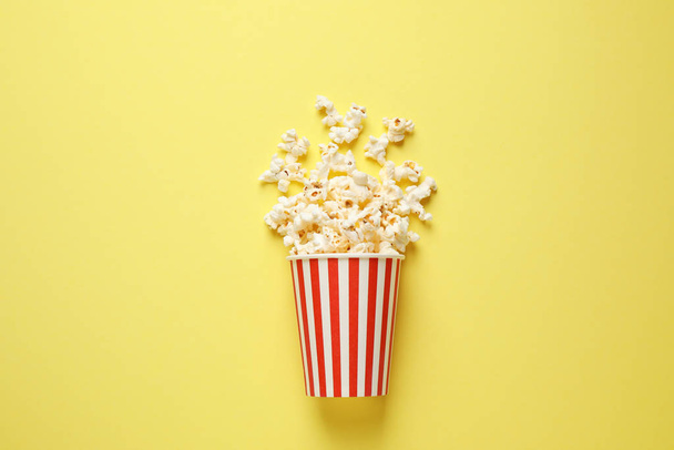 Delicious popcorn on yellow background, top view - Foto, imagen