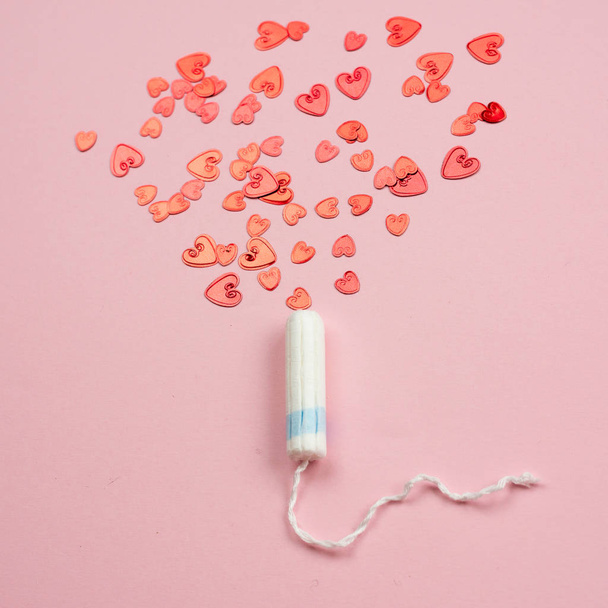 Medical female tampon on a pink background. Hygienic white tampon for women. Cotton swab. Menstruation, means of protection. - Fotoğraf, Görsel