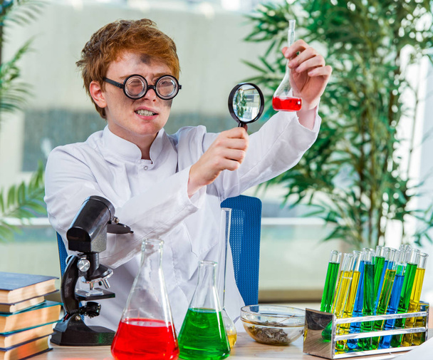 A laborban dolgozó fiatal őrült kémikus - Fotó, kép