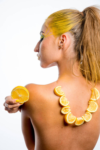 beautiful girl with yellow hair and a slice of lemon - Zdjęcie, obraz