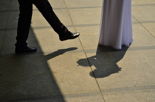 Groom is leaving dark side in his way to the marriage, stepping out the shadow - 写真・画像