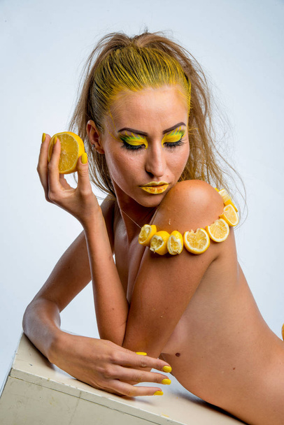 красива дівчина з жовтим волоссям і шматочком лимона
 - Фото, зображення