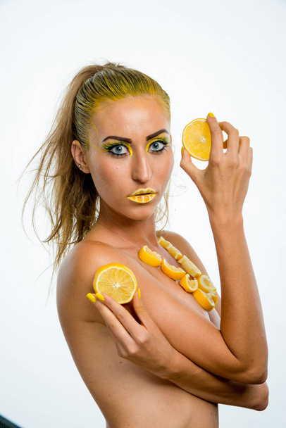 menina bonita com cabelo amarelo e uma fatia de limão
 - Foto, Imagem