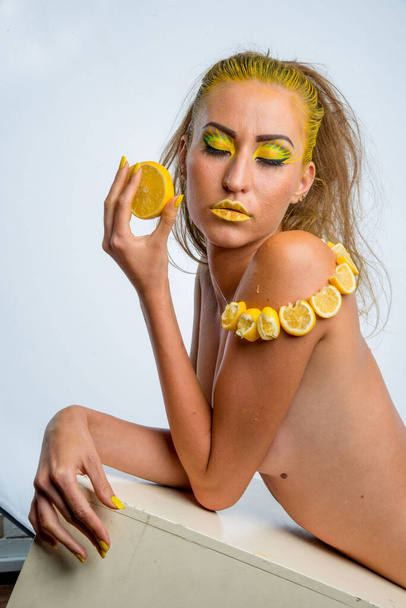 beautiful girl with yellow hair and a slice of lemon - Foto, Bild