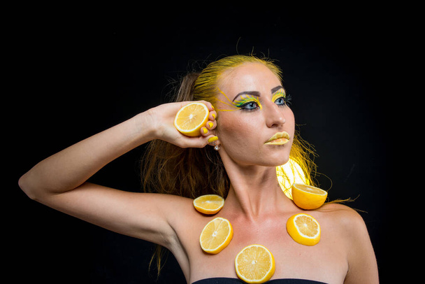 beautiful girl with yellow hair and a slice of lemon - Foto, imagen