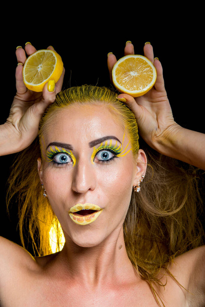 piękna dziewczyna z żółtymi włosami i plasterkiem cytryny - Zdjęcie, obraz