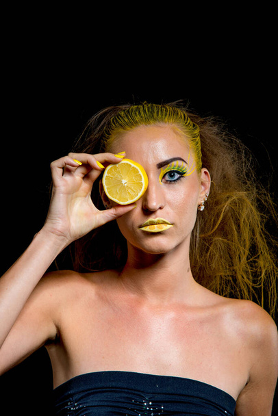 beautiful girl with yellow hair and a slice of lemon - 写真・画像