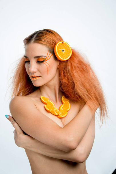 beautiful redhead girl with orange fruit  - Valokuva, kuva