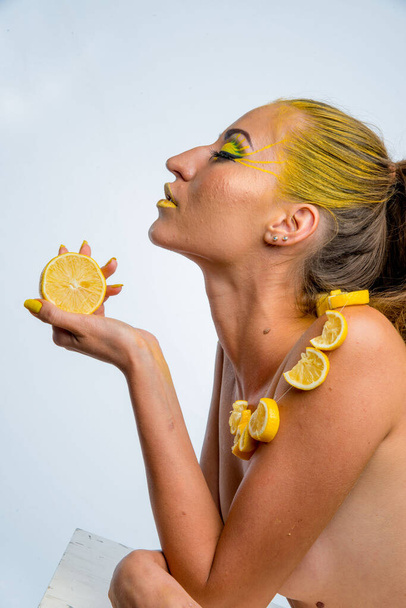 beautiful girl with yellow hair and a slice of lemon - Fotoğraf, Görsel