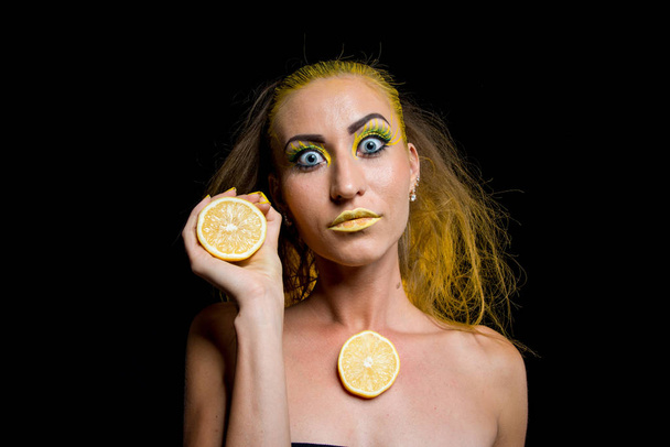 beautiful girl with yellow hair and a slice of lemon - Fotó, kép