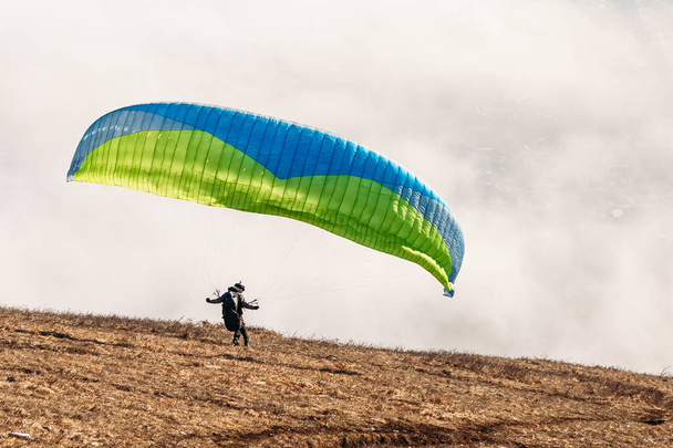 paraglider starting to paragliding above mountain - Фото, изображение