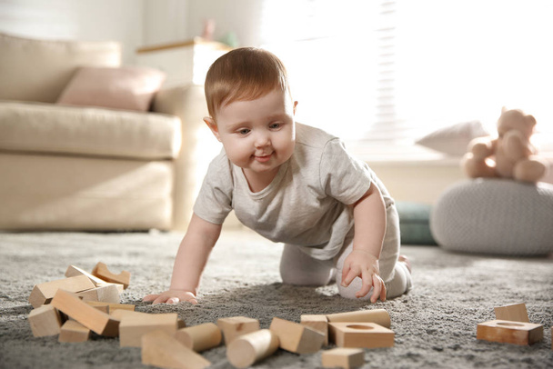 Cute baby playing with wooden blocks at home - Фото, изображение