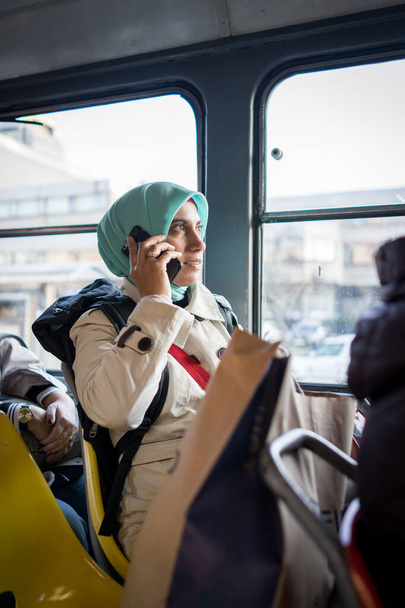 Muslim woman riding public transport in city - Foto, Imagen