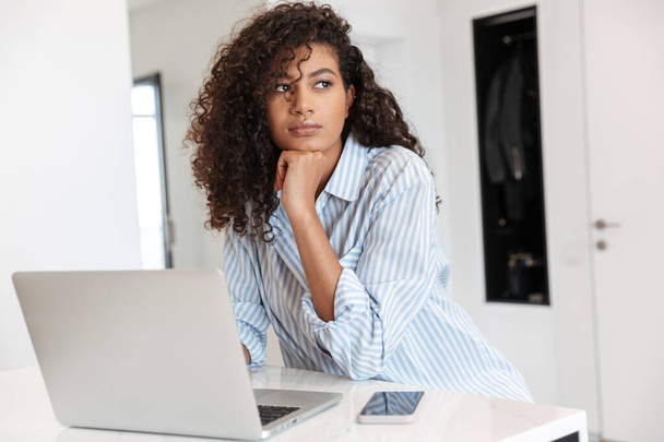 Attractive young african woman working on laptop computer - Photo, image