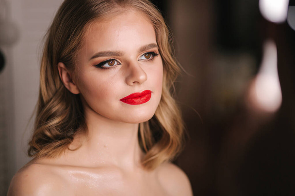 Portret van een mooie blonde haardame na make-up in de schoonheidssalon. Rode lippenstift. Ringlicht - Foto, afbeelding