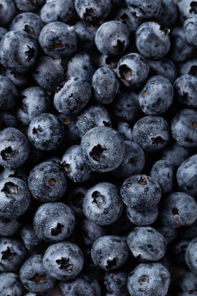 A closeup vertical shot of blueberries with water droplets - Fotó, kép