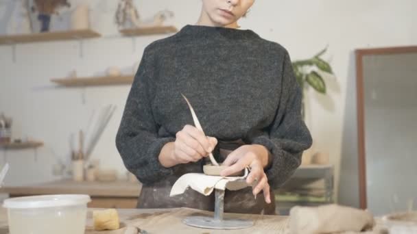 Keramiikka nainen seisoo lähellä työpöydän ja luoda keraaminen kuppi. Työskentely savea. Kämmentietokone
. - Materiaali, video