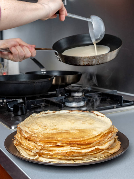 Freshly baked pancakes stacked on a platter from which steam comes. Traditional treat for the holiday of Maslenitsa. - Fotografie, Obrázek