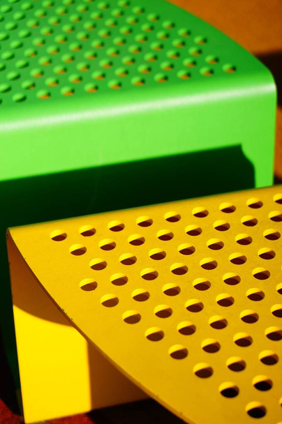 A vertical closeup shot of yellow and green seats for the children in the playground - Foto, afbeelding