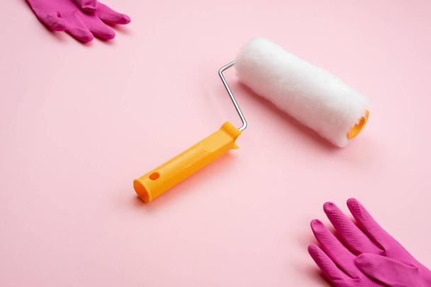 farba rolki i rękawice lateksowe leżące na ukośnej na różowym backgro - Zdjęcie, obraz