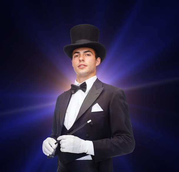 Magician in top hat with magic wand showing trick - Φωτογραφία, εικόνα