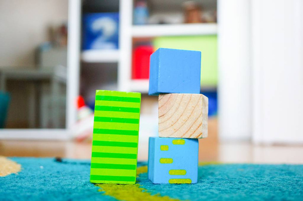 Green striped rectangular toy next to small square toys - 写真・画像