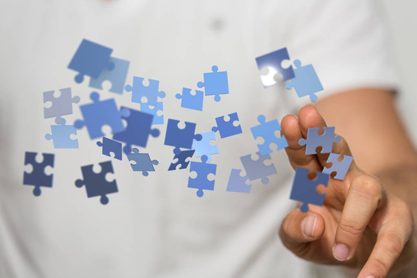 An illustration of different pieces of a jigsaw puzzle over someone's hand - Fotografie, Obrázek