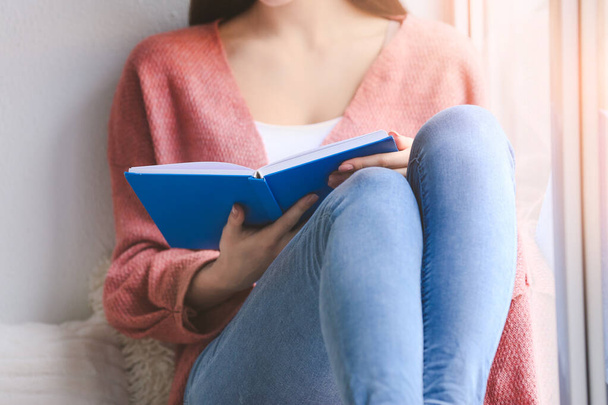 Молодая женщина читает книгу дома - Фото, изображение