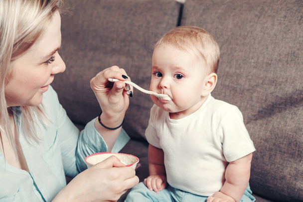 A happy mother feeds a little baby - Valokuva, kuva