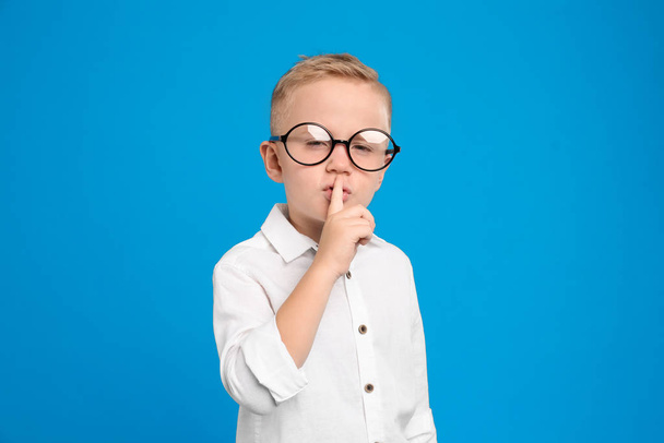 Portrait of cute little boy in glasses on light blue background - Foto, Imagem