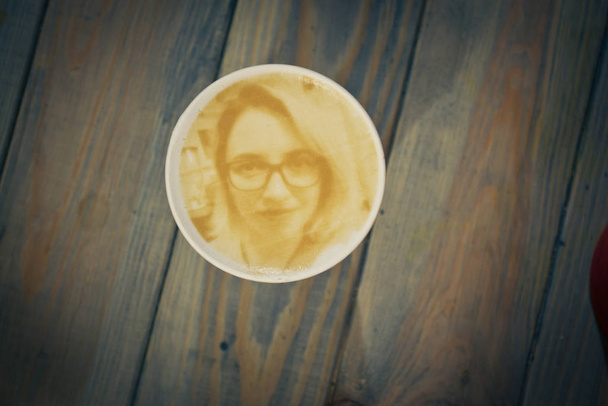 Disegno di una faccia di donne su un caffellatte di schiuma in un bicchiere creato da caffè
 - Foto, immagini