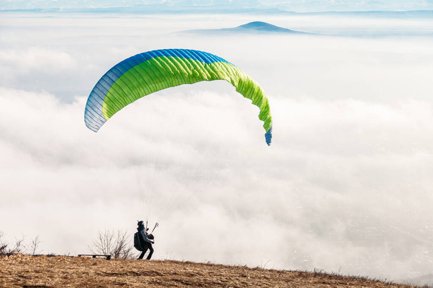 Pyatigorsk, Stavropol Territory / Russia - January 21, 2019: paraglider starting to paragliding above mountain - 写真・画像