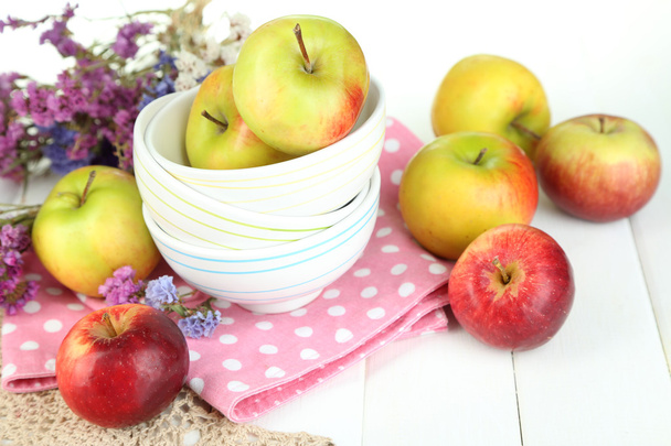 Juicy apples on plate on white wooden table - 写真・画像
