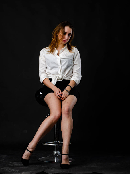 beautiful woman in black skirt posing in studio isolated on a dark background - Foto, Imagem