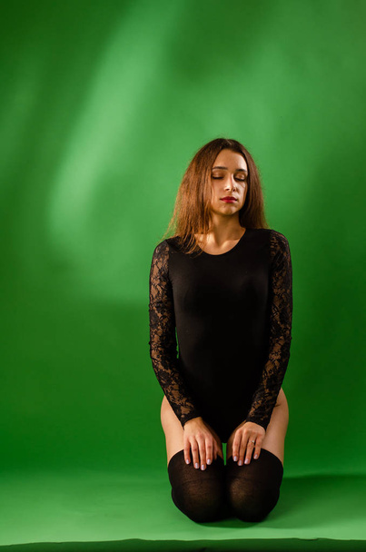 menina em preto bodysuit no fundo verde
 - Foto, Imagem