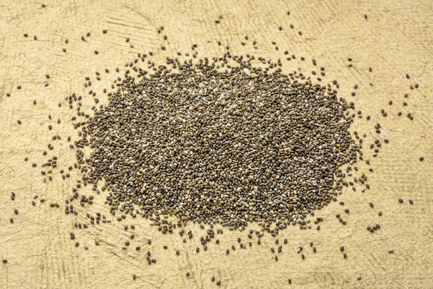 chia seeds pile against textured paper - Fotoğraf, Görsel