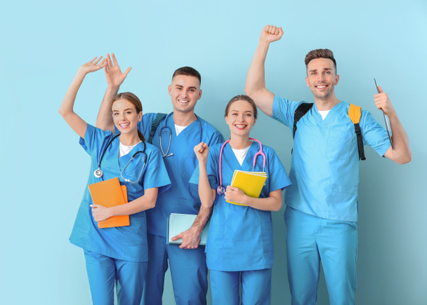 Group of happy medical students on color background - 写真・画像