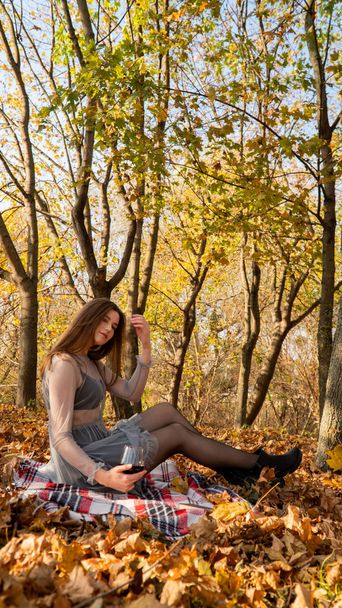 молода красива жінка з келихом вина в парку восени
 - Фото, зображення