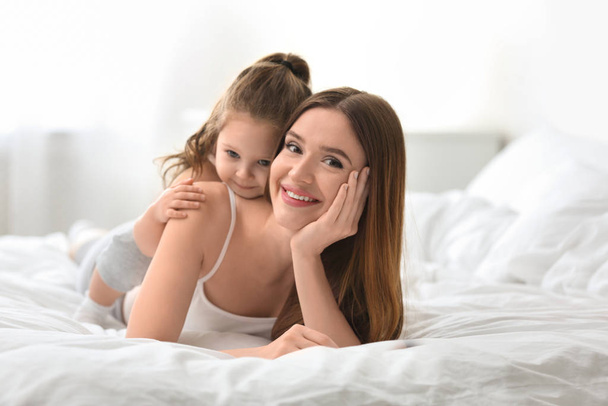 Happy mother with little daughter in bedroom - Foto, Imagen