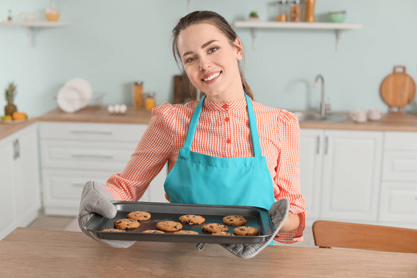 Young housewife with cookies in kitchen - 写真・画像