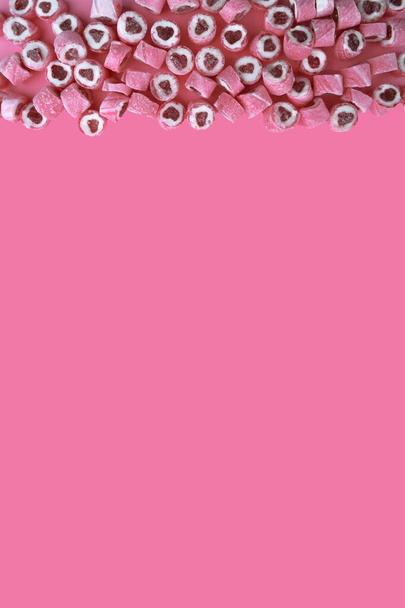 Pink candy hearts on a pink background. Romantic background with copy space - Photo, Image