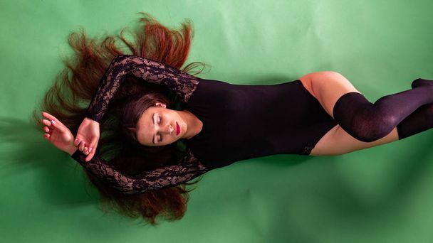 kaunis tyylikäs muodikas tyttö kehonpuku nahkatakit poseeraa valokuva Studio tummalla pohjalla ketjuilla
 - Valokuva, kuva