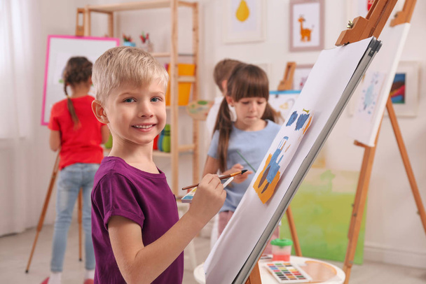 Cute little child painting during lesson in room - Φωτογραφία, εικόνα