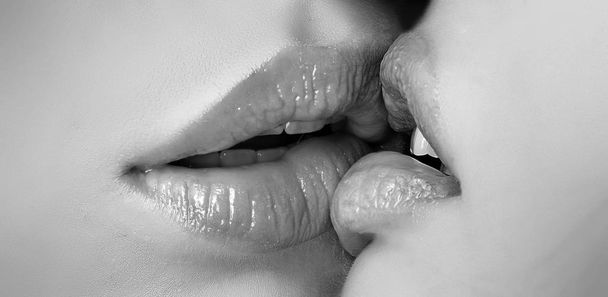 Kiss lesson. Two women friends kissing. Two beautiful sexy lesbians in love. Closeup of women mouths kissing. Passionate kissing. Sexy plump full lips. Lipstick and lipgloss. - Foto, afbeelding