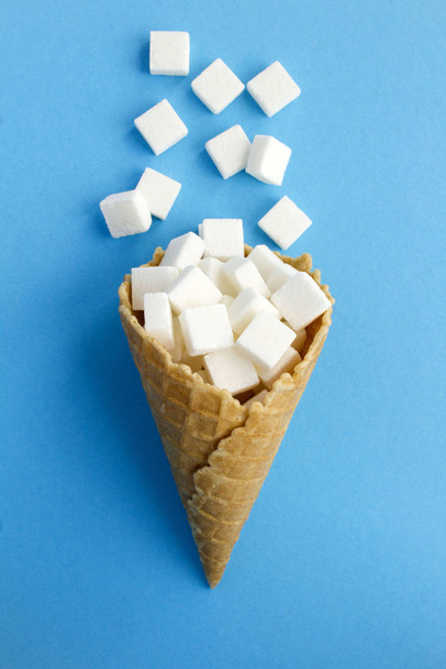 Jäätelö kartio valkoinen sokeri sinisellä pohjalla. Huippunäkymä. Kopioi tilaa. Sijainti vertical.Creative ruoka kollaasi
. - Valokuva, kuva