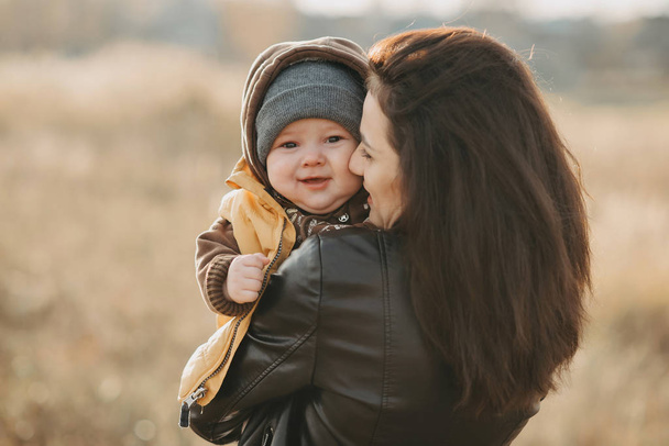 glückliche Mutter und Sohn. junges Mädchen lachend umarmt ihr Baby - Foto, Bild