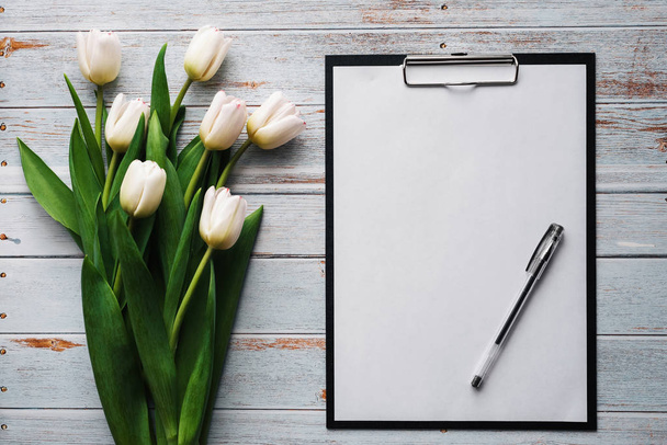 weißer Strauß Tulpen auf blauem Holzgrund mit leerem Papiertablett - Foto, Bild