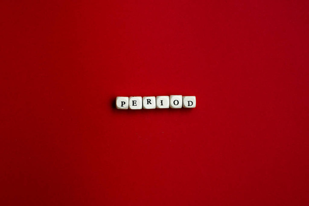 The word "Period" is laid out of dice on a red background - Photo, Image